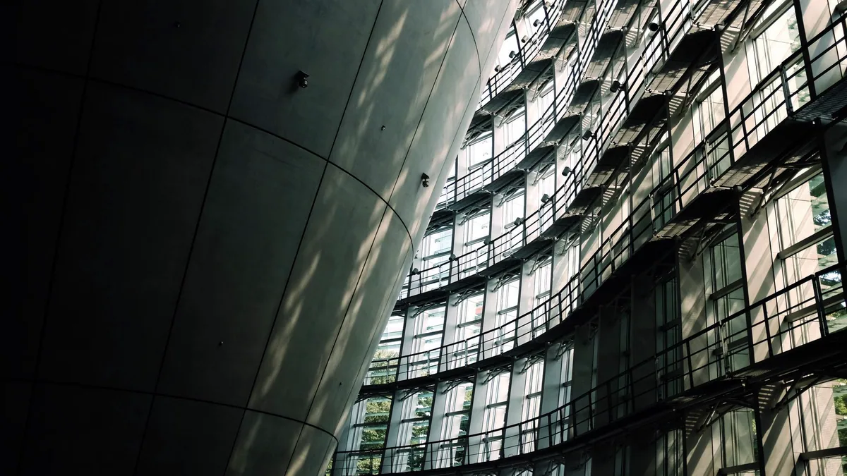 A sweeping curved concrete wall of a museum catching the morning light.