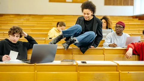 A student taking notes in a large lecture hall.