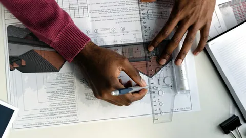 A detailed blueprint drawing of a building spread across a table.