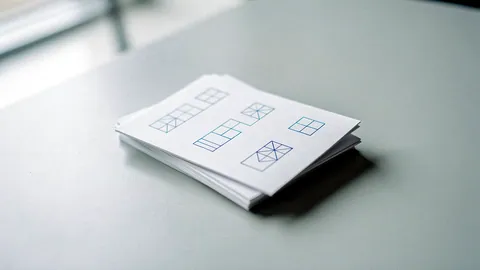 Illustration: A small stack of white cards with clean geometric blue line diagrams on a desk.
