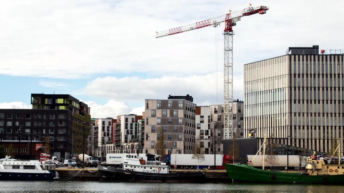 A tall crane standing over a busy building site in the city.