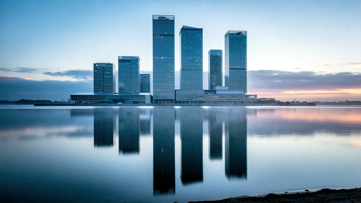 Illustration: A glass tower skyline mirrored in still water at dawn.