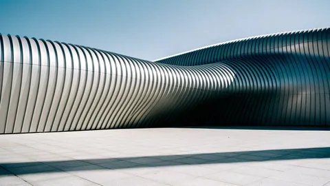 Illustration: A curved corrugated metal facade in rippling silver panels over a small public square.